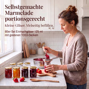 Frau beim Befüllen kleiner Helix-Gläser mit Marmelade – Deckelfarbe Gold · Anwendungsszene mit KI-generierter Person