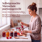 Frau beim Befüllen kleiner Helix-Gläser mit Marmelade – Deckelfarbe Rot-Gold · Anwendungsszene mit KI-generierter Person