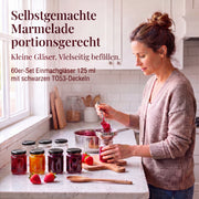 Frau beim Befüllen kleiner Helix-Gläser mit Marmelade – Deckelfarbe Schwarz · Anwendungsszene mit KI-generierter Person