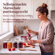 Frau beim Befüllen kleiner Helix-Gläser mit Marmelade – Deckelfarbe Silber · Anwendungsszene mit KI-generierter Person